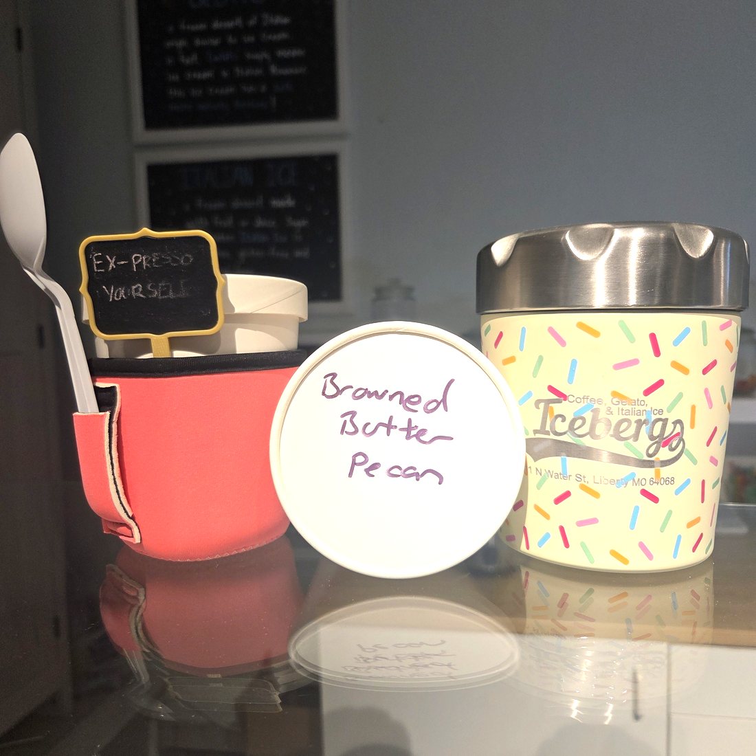 Two Icebergs pints on the counter, one in the printed sprinkle cup, the other with Browned Butter Pecan written on the lid in marker.